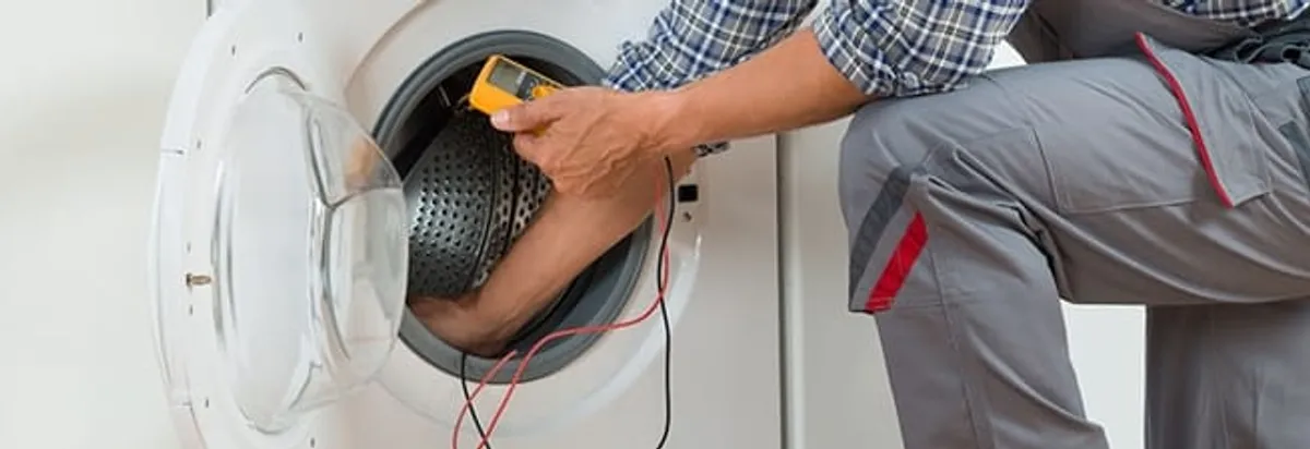 Dryer repair technician inspecting and repairing a clothes dryer in Toledo, OH