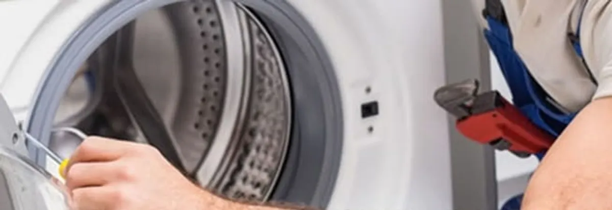 Appliance technician repairing a clothes dryer drum and internal parts in Toledo, OH