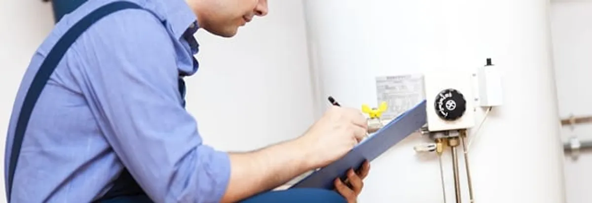 Water heater repair technician inspecting the unit and recording service notes in Toledo, OH